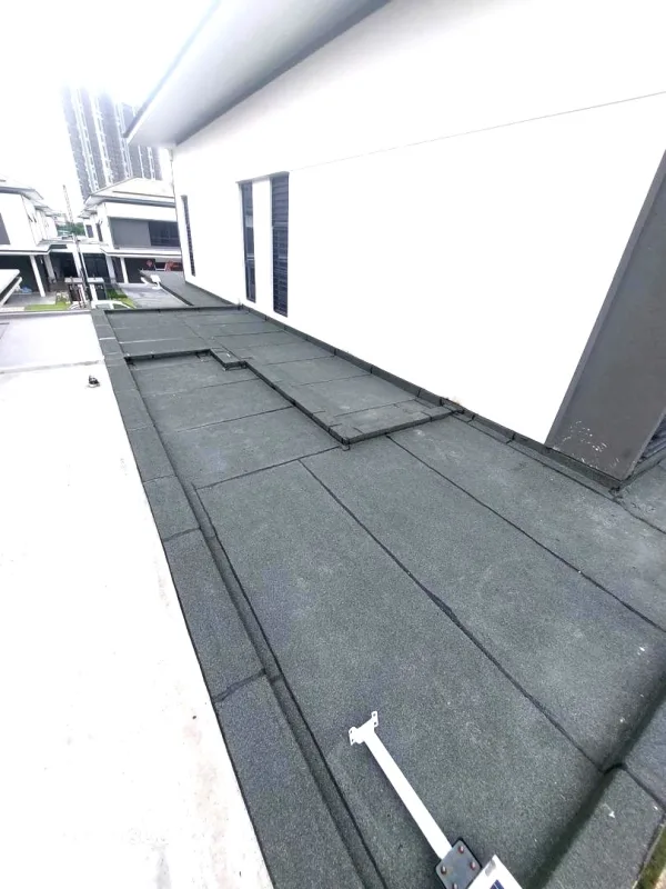 Professional torch-on bitumen waterproofing applied to a rooftop balcony.