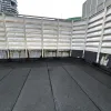 Heat-fused torch-on waterproofing membrane being rolled on concrete surface